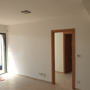 קיר צבוע בלבן עם גליל נייר על הרצפה