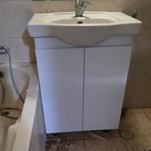 כיור עם ארון מתחתיו בחדר אמבטיה