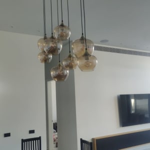 נברשת תלויה מעל שולחן אוכל בחדר פנימי