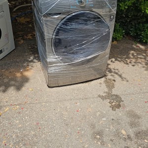 מכונת כביסה עטופה בניילון על שביל חיצוני