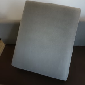 כרית ספה אפורה על ספה חומה