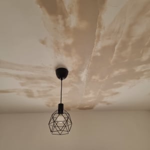 תקרה עם תיקוני צבע ומנורה תלויה