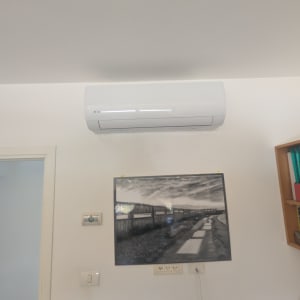 מזגן מותקן על קיר בחדר עם תמונה