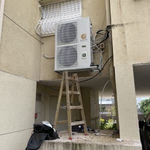 יחידת מיזוג אוויר מותקנת על קיר חיצוני עם סולם