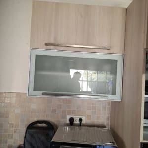 ארון מטבח עם דלת זכוכית ומכשירי חשמל