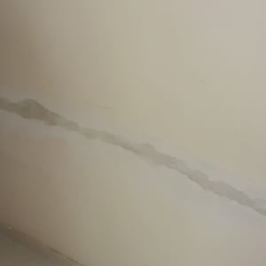 קיר עם סימני תיקון ושקע חשמלי