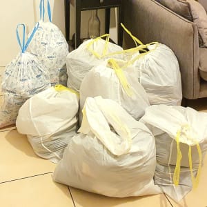 שקיות אשפה קשורות מונחות על רצפת אריחים