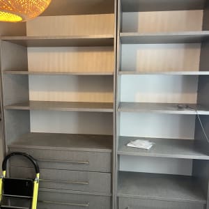 ארון מדפים ריק עם סולם קטן לידו