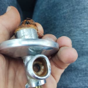 חלק מתכת עם חוטי פשתן ביד של אדם