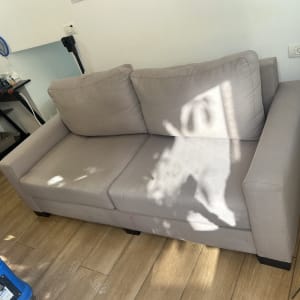 ספת בד אפורה בבית הלקוח לצד ציוד מקצועי לניקוי ספות