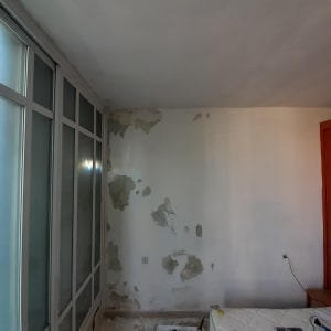 הכנת קיר וקילוף צבע רופף לקראת צביעה בחדר מרוהט