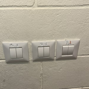 שלושה מתגים חשמליים על קיר לבן