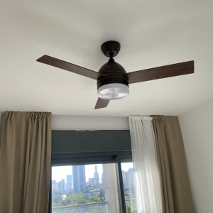 מאוורר תקרה בחדר עם וילונות וחלון