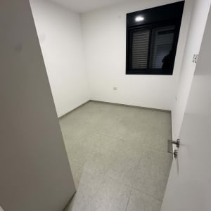 חדר ריק עם רצפת אריחים וקיר לבן