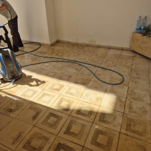 מכונת ניקוי על רצפת אריחים עם צינור