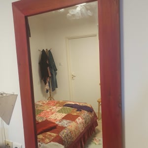 מראה עם מסגרת עץ בחדר שינה