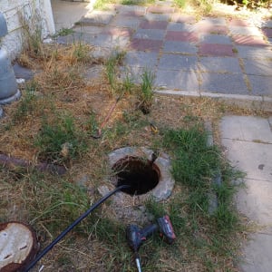 כלי עבודה ליד פתח ביוב בחצר