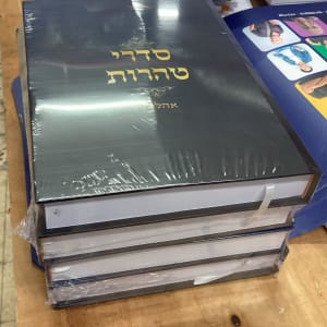 ספרים מודפסים בערימה על שולחן בעבודת דפוס