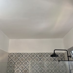 תקרה צבועה עם אריחים מעוצבים במקלחת