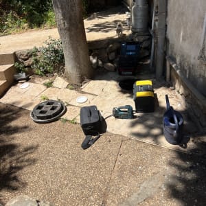 כלים וציוד ליד עץ וצינורות בחצר