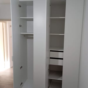 ארון לבן עם דלתות פתוחות ומדפים פנימיים