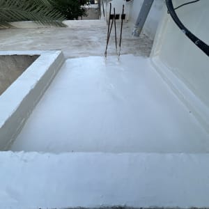 גג שטוח עם ציפוי לבן, כבלים חשמליים ועמודים חשופים