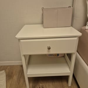 שידת לילה לבנה עם מגירה על רצפת עץ