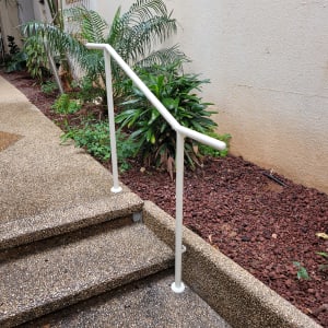 מעקה מתכת לבן על מדרגות חיצוניות