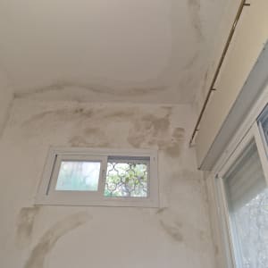 קיר עם סימני רטיבות ותקרה צבועה חלקית