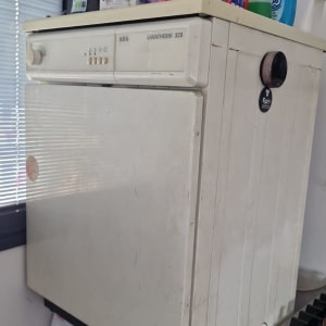 מכונת כביסה עם חומרי ניקוי על גבי המכסה