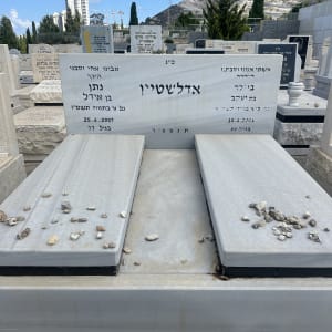 מצבות עם אבנים קטנות מונחות עליהן בבית קברות