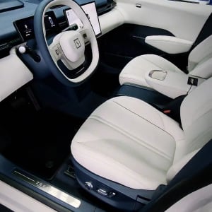 פנים רכב עם מושבים לבנים והגה מודרני