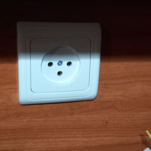 שקע חשמלי בקיר עם חוטים חשמליים צבעוניים