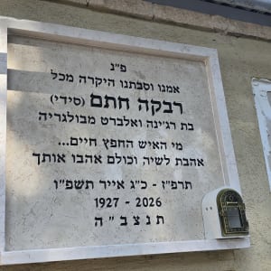 מצבה עם כיתוב בעברית על קיר חיצוני