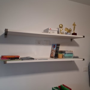 מדפים עם ספרים ופרסים על קיר לבן