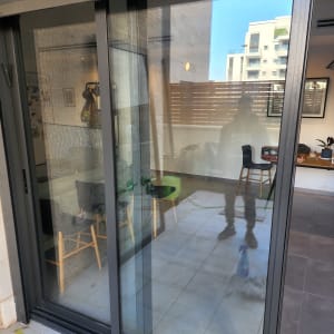 דלת זכוכית עם השתקפות של אדם ומרפסת