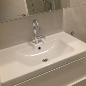 כיור וארון רחצה מבריקים ונקיים בחדר רחצה לאחר ניקיון