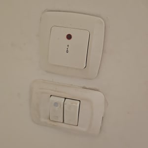 שני מתגי חשמל על קיר לבן