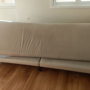 ספה בהירה בחדר עם רצפת עץ