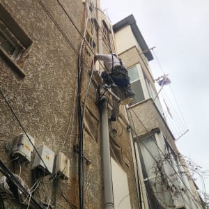 אדם מטפס על קיר בניין עם ציוד בטיחות