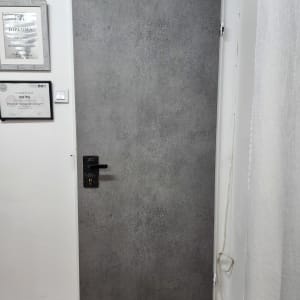 דלת מצופה עם ידית שחורה ותעודות על הקיר