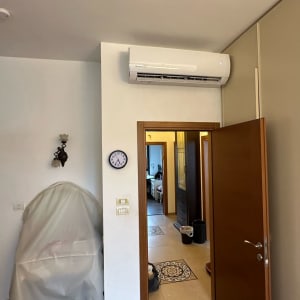 מזגן מותקן על קיר מעל דלת פתוחה