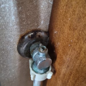 ברז מים חלוד עם צינור מחובר לקיר