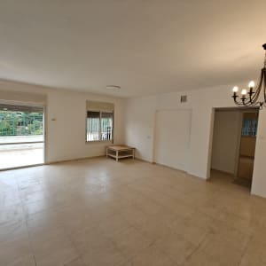 חדר ריק עם רצפת אריחים ונברשת תקרה