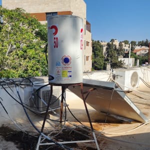דוד שמש על גג עם קולטים וצינורות