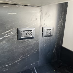 שני שקעי חשמל בקיר שיש כהה