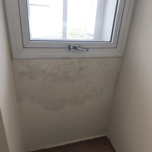 קיר עם סימני רטיבות מתחת לחלון