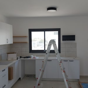 סולם אלומיניום במטבח עם כלים על השיש