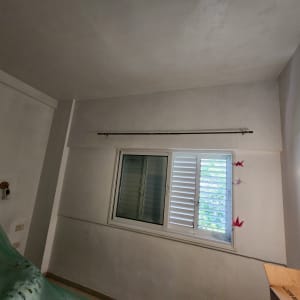 קיר צבוע בלבן עם מנורה דולקת