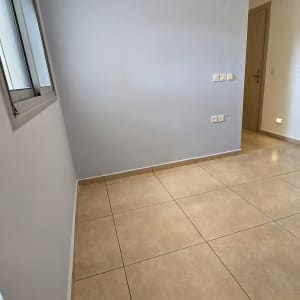 קיר צבוע בגוון כחול בהיר עם רצפת אריחים